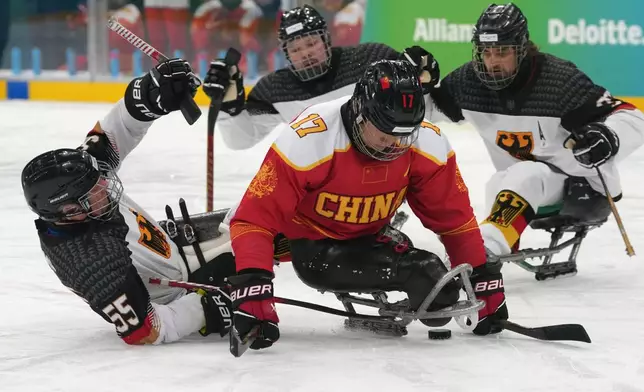 Germany's Sven Stumpe, left, and China's Yifeng Shen challenge for the puck during the Group A hockey match between China and Germany at the 2026 Winter Paralympics, in Milan, Italy, Saturday, March 7, 2026. (AP Photo/Antonio Calanni)