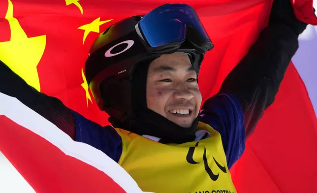 Wu Zhongwei, of China, celebrates after winning the gold medal in the men's snowboard cross SB-LL1 at the 2026 Winter Paralympics, in Cortina d'Ampezzo, Italy, Sunday, March 8, 2026. (AP Photo/Emilio Morenatti)