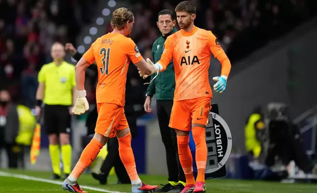 Tottenham's goalkeeper Antonin Kinsky, left, shakes hands with Tottenham's goalkeeper Guglielmo Vicario after substitution during the first leg of the Champions League round of 16 soccer match between Atletico Madrid and Tottenham in Madrid, Spain, Tuesday, March 10, 2026. (AP Photo/Jose Breton)
