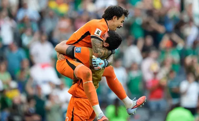 Bolivia's goalkeeper Guillermo Viscarra, top, and goalkeeper Carlos Lampe celebrate at the end of a World Cup playoff semifinal soccer match between Bolivia and Suriname in Monterrey, Mexico, Thursday, March 26, 2026. (AP Photo/Fernando Llano)