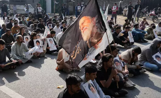 Pakistani Shiite Muslims sit on a road during a demonstration to condemn the death of Iranian Supreme Leader Ayatollah Ali Khamenei in a major attack by Israel and the United States, in Lahore, Pakistan, Sunday, March 1, 2026. (AP Photo/K.M. Chaudary)