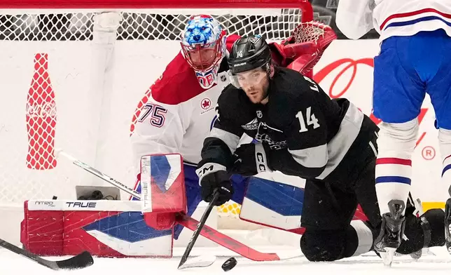 Los Angeles Kings right wing Alex Laferriere, right, passes the puck as Montréal Canadiens goaltender Jakub Dobes sits in goal during the first period of an NHL hockey game Saturday, March 7, 2026, in Los Angeles. (AP Photo/Mark J. Terrill)