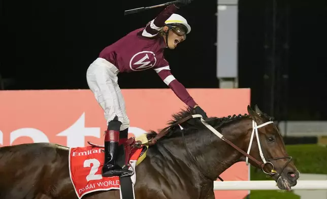 Jockey Jose Ortiz, aboard Magnitude, celebrates winning the $12 million Dubai World Cup horse race over 2000m (10 furlongs) at Meydan Racecourse in Dubai, the United Arab Emirates, Saturday, March 28, 2026. (AP Photo/Altaf Qadri)