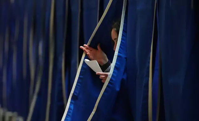 A person exits a polling booth at a polling station at City Hall in Copenhagen, Denmark, on Tuesday, March 24, 2026, during the general election. (AP Photo/Sergei Grits)