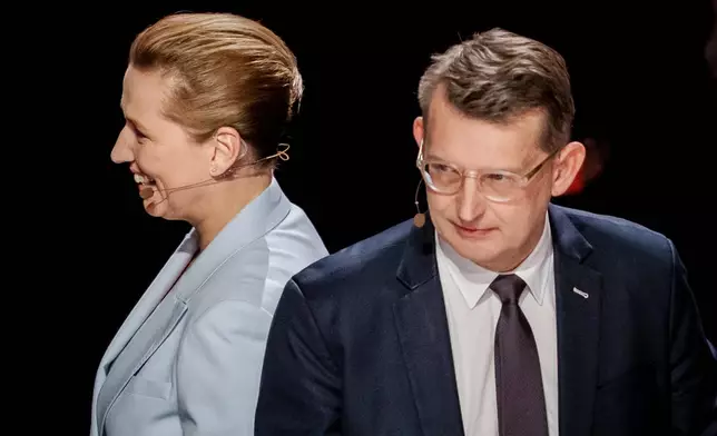 Denmark's Prime Minister Mette Frederiksen, left, and Defense Minister Troels Lund Poulsen, right, attend the party leader debate Democracy's Evening on DR1 at the Concert Hall, DR City in Copenhagen, Sunday, March 22, 2026. (Mads Claus Rasmussen/Ritzau Scanpix via AP)