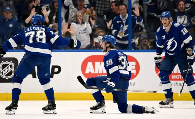 Tampa Bay Lightning defenseman Emil Lilleberg (78), left wing Brandon Hagel (38) and right wing Corey Perry (10) celebrate Hagel's goal during the third period of an NHL hockey game against the Nashville Predators, Sunday, March 29, 2026, in Tampa, Fla. (AP Photo/Jason Behnken)