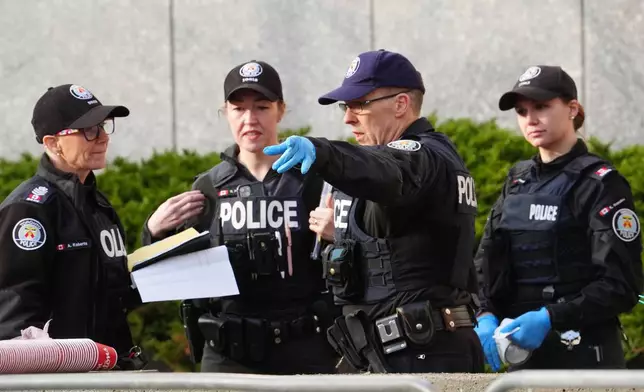 Toronto police investigate the scene after the U.S. consulate was hit by gunfire in Toronto on Tuesday March 10, 2026. (Frank Gunn/The Canadian Press via AP)