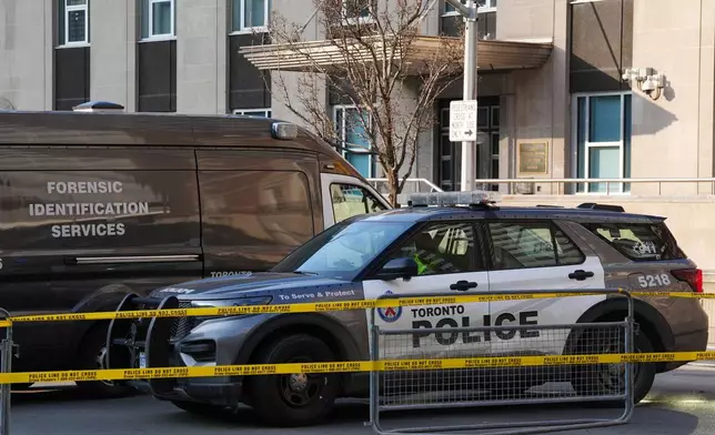 Police vehicles are parked by the U.S. consulate after it was hit by gunfire in Toronto on Tuesday March 10, 2026. (Frank Gunn /The Canadian Press via AP)