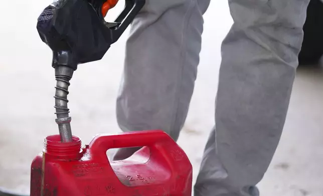 Nate Collins fills a gas can for his landscaping tools Monday, March 9, 2026, in Arlington, Texas. (AP Photo/Julio Cortez)