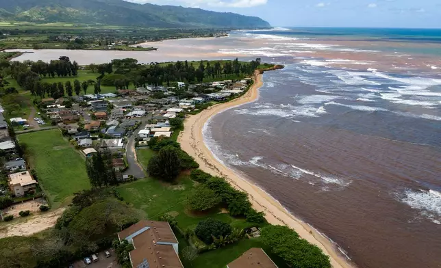 An aerial view shows discolored water along the North Shore coastline, Tuesday, March 24, 2026, in Haleiwa, Hawaii. (AP Photo/Mengshin Lin)