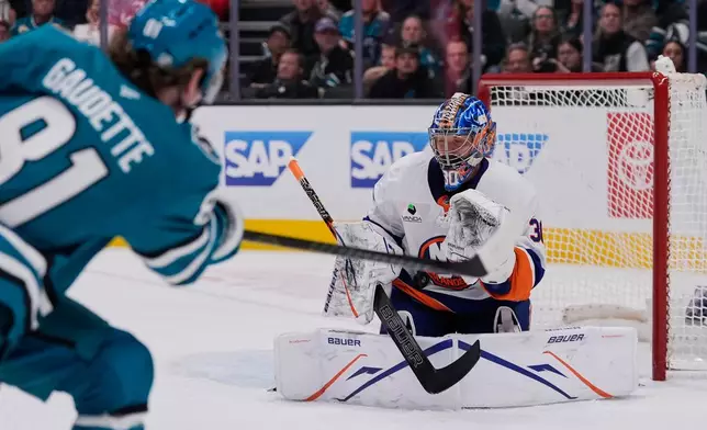 New York Islanders goaltender Ilya Sorokin (30) stops a shot by San Jose Sharks right wing Adam Gaudette, foreground, during the first period of an NHL hockey game, Saturday, March 7, 2026, in San Jose, Calif. (AP Photo/Godofredo A. Vásquez)