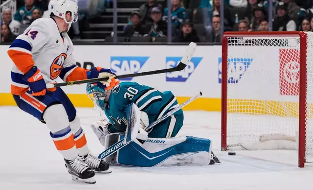 San Jose Sharks goaltender Yaroslav Askarov (30) is unable to stop a goal by New York Islanders center Bo Horvat (14) during overtime of an NHL hockey game, Saturday, March 7, 2026, in San Jose, Calif. (AP Photo/Godofredo A. Vásquez)