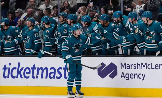 San Jose Sharks center Macklin Celebrini (71) celebrates with teammates after scoring a goal during the second period of an NHL hockey game against the New York Islanders, Saturday, March 7, 2026, in San Jose, Calif. (AP Photo/Godofredo A. Vásquez)