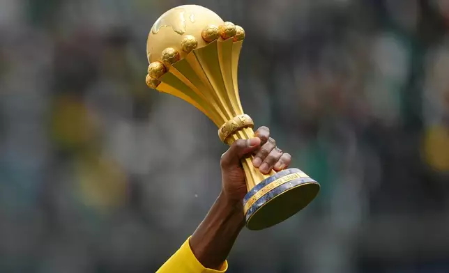 A Senegal player holds the Africa Cup of Nations trophy ahead of the international friendly soccer match between Senegal and Peru in Saint-Denis, outside of Paris, Saturday, March 28, 2026. (AP Photo/Aurelien Morissard)