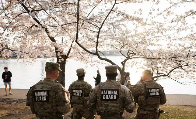 Members of the Mississippi National Gard patrol among the cherry blossom trees along the tidal basin on the National Mall on Thursday, March 26, 2026, in Washington. (AP Photo/Tom Brenner)