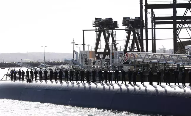 Members of the French Navy are aboard a submarine awaiting the arrival of French President Emmanuel Macron at the nuclear submarine navy base of Ile Longue in Crozon, France, Monday March 2, 2026. (Yoan Valat/Pool Photo via AP)