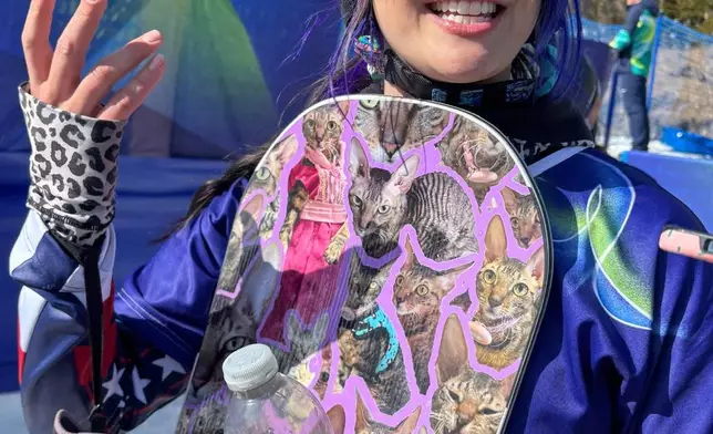 Brenna Huckaby, of the United States gestures as she speaks holding her snowboard at the 2026 Winter Paralympics, in Cortina d'Ampezzo, Italy, Saturday, March 7, 2026. (AP Photo/Tales Azzoni)