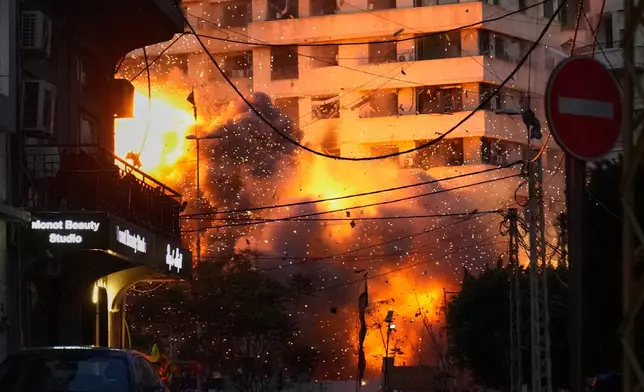 An explosion erupts from a building following an Israeli strike in central Beirut, Lebanon, Wednesday, March 18, 2026. (AP Photo/Hussein Malla)