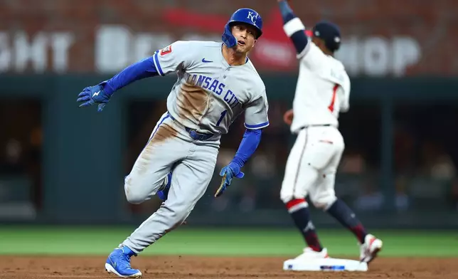 Kansas City Royals' Isaac Collins, left, rounds second base during the third inning of a baseball game against the Atlanta Braves, Saturday, March 28, 2026, in Atlanta. (AP Photo/Colin Hubbard)