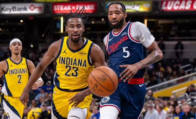 Indiana Pacers guard Aaron Nesmith (23) and Los Angeles Clippers forward Derrick Jones Jr. (5) chase the ball during the first half of an NBA basketball game in Indianapolis, Friday, March 27, 2026. (AP Photo/Doug McSchooler)