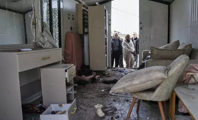 Palestinians inspect the damage at a beauty salon after a deadly Iranian strike in the West Bank village of Beit Awa, near Hebron, Thursday, March 19, 2026. (AP Photo/Mahmoud Illean)
