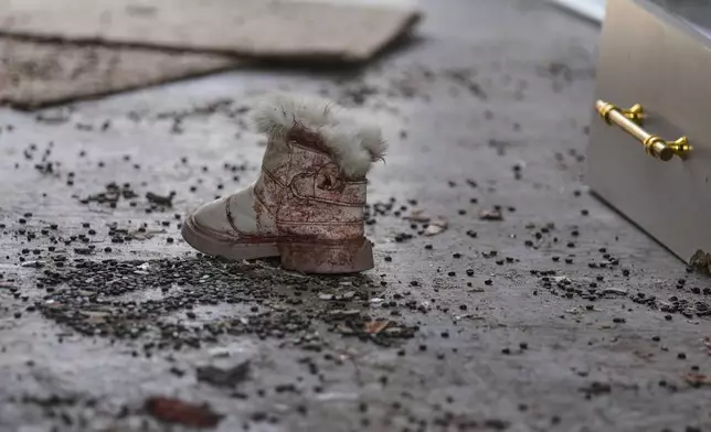 A bloodied shoe is seen among rubble at a beauty salon damaged in a deadly Iranian strike in the West Bank village of Beit Awa, near Hebron, Thursday, March 19, 2026. (AP Photo/Mahmoud Illean)