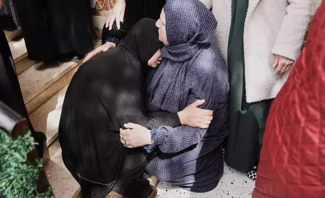 Palestinian women mourn during the funeral of three Palestinian women who were killed in an Iranian strike in the West Bank village of Beit Awa, near Hebron, Thursday, March 19, 2026. (AP Photo/Mahmoud Illean)