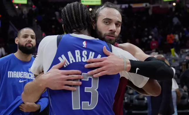 Cleveland Cavaliers guard Max Strus, right, embraces Dallas Mavericks forward Naji Marshall (13) after their NBA basketball game in Cleveland, Sunday, March 15, 2026. (AP Photo/Sue Ogrocki)