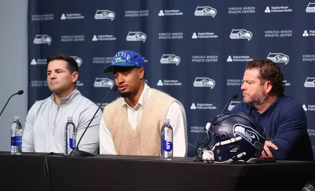 Seattle Seahawks wide receiver Jaxon Smith-Njigba, center, speaks with media during an NFL football news conference on Wednesday, March 25, 2026, in Seattle. (AP Photo/Kevin Ng)