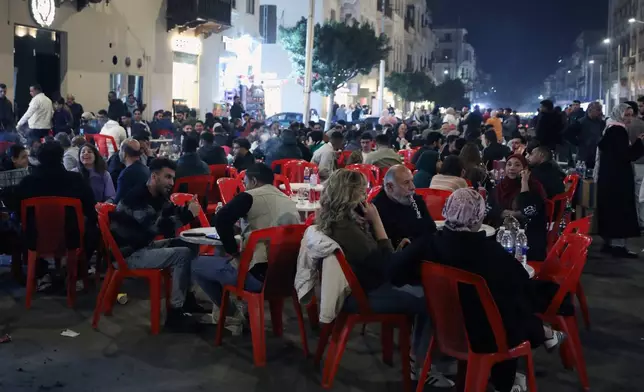 People crowd at a coffee shop to catch time before earlier closing hours applied, as part of a series of measures the government has taken to mitigate the fallout of the U.S. and Israeli war against Iran, in Cairo, Egypt, Saturday, March 28, 2026. (AP Photo/Khaled Elfiqi)