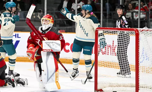 Seattle Torrent's Jessie Eldridge, right, celebrates her goal on Ottawa Charge goaltender Gwyneth Philips (33) during the second period of an PWHL hockey game in Ottawa, Ontario, Wednesday, March 4, 2026. (Spencer Colby/The Canadian Press via AP)