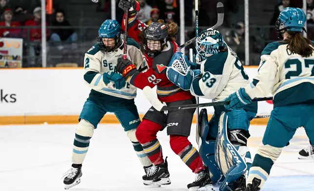 Seattle Torrent goaltender Hannah Murphy (83) looks for the puck as she is screened by Ottawa Charge's Sarah Wozniewicz (23) during the first period of an PWHL hockey game in Ottawa, Ontario, Wednesday, March 4, 2026. (Spencer Colby/The Canadian Press via AP)