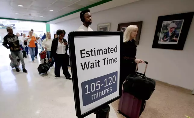 Air travelers wait in line as they progress to the TSA security checkpoint in Terminal A at the George Bush Intercontinental Airport, Monday, March 23, 2026, in Houston. (AP Photo/Michael Wyke)