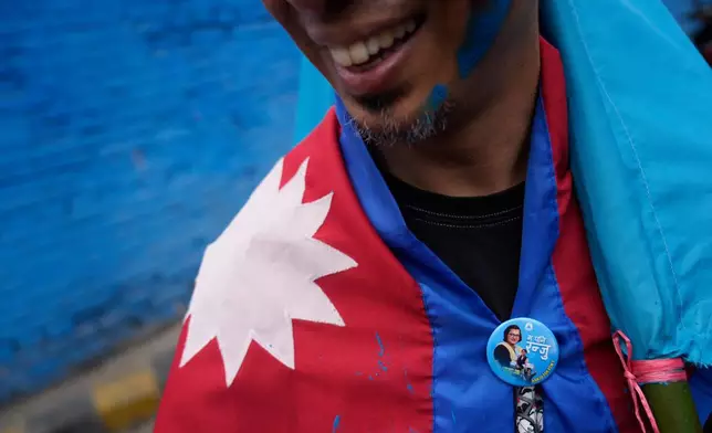 A supporter of Rastriya Swatantra Party celebrates the victory of Ranju Darshana, a candidate for a seat in the House of Representatives in Kathmandu, Nepal, Friday, March 6, 2026. (AP Photo/Niranjan Shrestha)