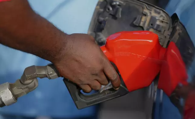 FILE - A service employee is filling a car with fuel at a petrol station in Lagos, Nigeria, March 23, 2026. (AP Photo/Sunday Alamba, File)