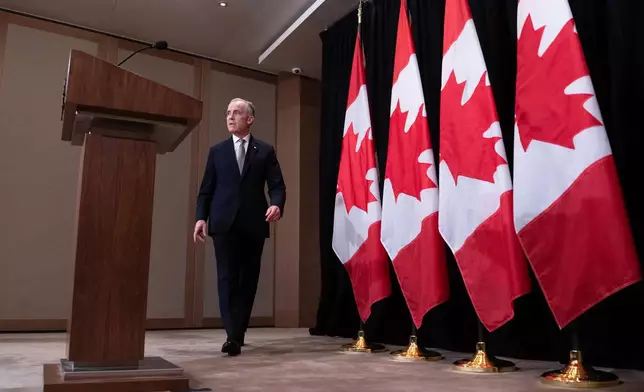 Canada's Prime Minister Mark Carney makes his way to the podium to speak with reporters, in Sydney, Australia, Wednesday, March 4, 2026. (Adrian Wyld/The Canadian Press via AP)