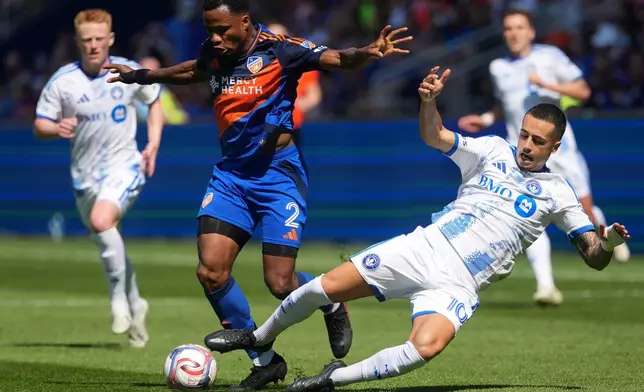 FC Cincinnati defender Alvas Powell (2) takes the ball from CF Montréal midfielder Iván Jaime (10) during the first half of an MLS soccer match, Sunday, March 22, 2026, in Cincinnati. (AP Photo/Kareem Elgazzar)