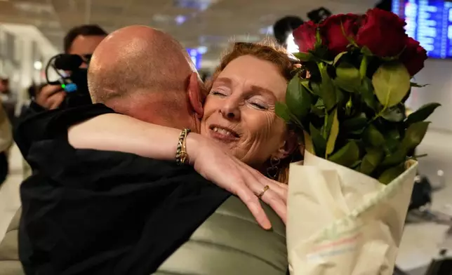 People arrive at the International Airport in Frankfurt, Germany, after being evacuated from Dubai on a commercial flight, Tuesday, March 3, 2026. (AP Photo/Michael Probst)