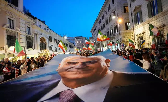 Demonstrators display a banner with Iran's exiled Crown Prince Reza Pahlavi as they gather in Rome, Tuesday, March 3, 2026. (AP Photo/Alessandra Tarantino)