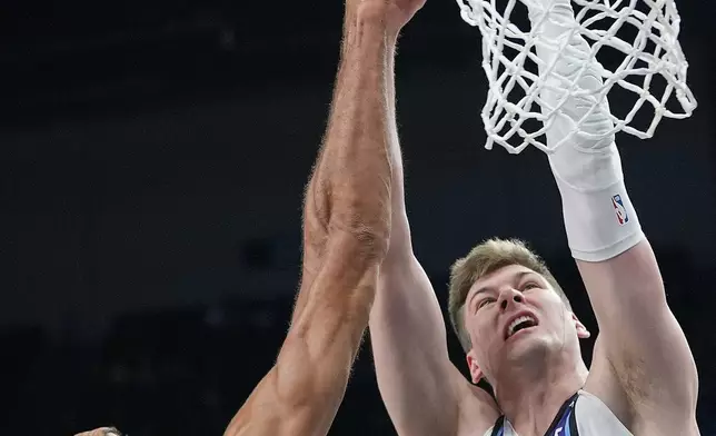 Minnesota Timberwolves center Rudy Gobert (27) blocks a shot by Utah Jazz forward Kyle Filipowski (22) during the first half of an NBA basketball game, Wednesday, March 18, 2026, in Minneapolis. (AP Photo/Abbie Parr)