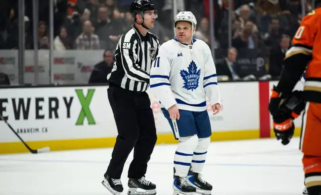 Toronto Maple Leafs center Max Domi (11) is escorted out of an NHL hockey game during the second period against the Anaheim Ducks, Monday, March 30, 2026, in Anaheim, Calif. (AP Photo/William Liang)