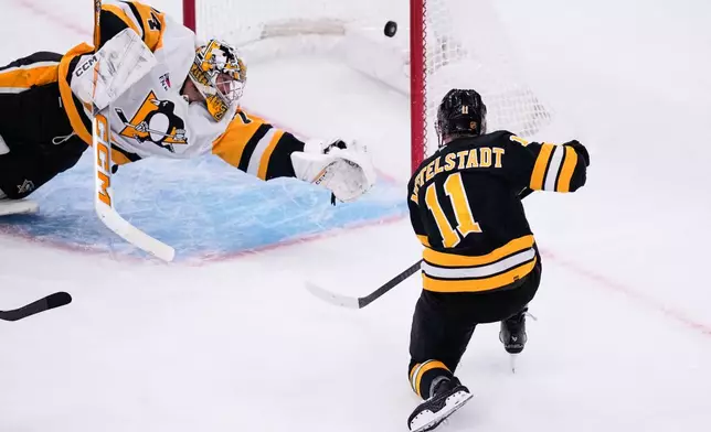 Boston Bruins center Casey Mittelstadt (11) scores on Pittsburgh Penguins goaltender Stuart Skinner (74) during the first period of an NHL hockey game, Tuesday, March 3, 2026, in Boston. (AP Photo/Charles Krupa) nn