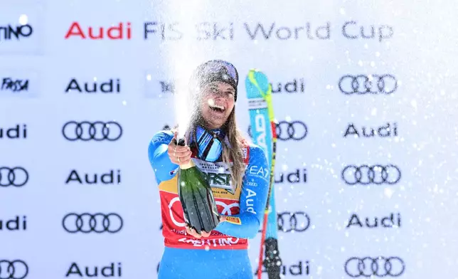 Italy's Laura Pirovano celebrates on the podium after winning an alpine ski, women's World Cup downhill, in Val di Fassa, Italy, Saturday, March 7, 2026. (AP Photo/Marco Trovati)