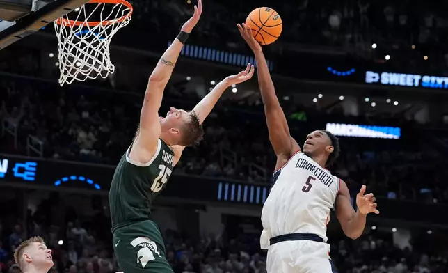 UConn forward Tarris Reed Jr. (5) rebounds over Michigan State center Carson Cooper (15) during the second half in the Sweet 16 of the NCAA college basketball tournament, Saturday, March 28, 2026, in Washington. (AP Photo/Stephanie Scarbrough)