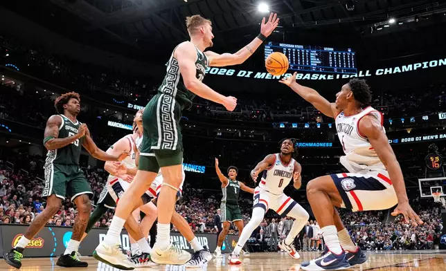 Michigan State center Carson Cooper (15) and UConn forward Tarris Reed Jr. (5) vie for the ball during the second half in the Sweet 16 of the NCAA college basketball tournament, Friday, March 27, 2026, in Washington. (AP Photo/Abbie Parr)