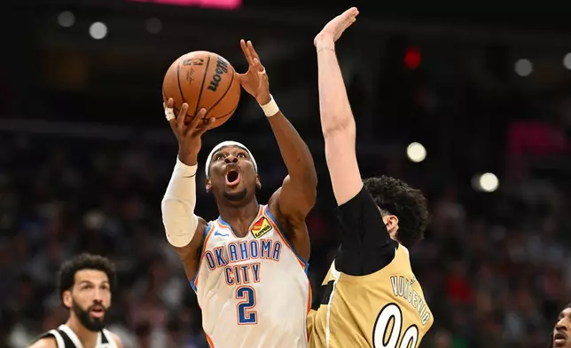 Oklahoma City Thunder guard Shai Gilgeous-Alexander (2) goes to the basket against Washington Wizards forward Tristan Vukcevic (00) during the first half of an NBA basketball game, Saturday, March 21, 2026, in Washington. (AP Photo/Nick Wass)