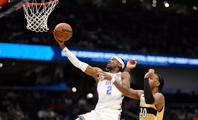 Oklahoma City Thunder guard Shai Gilgeous-Alexander (2) goes to the basket past Washington Wizards center Alex Sarr (20) during the first half of an NBA basketball game, Saturday, March 21, 2026, in Washington. (AP Photo/Nick Wass)