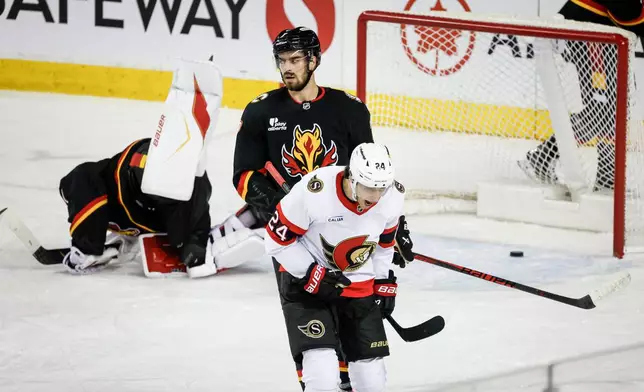 Ottawa Senators' Dylan Cozens, right, celebrates his goal as Calgary Flames' Kevin Bahl looks away during the third period of an NHL hockey game in Calgary, Alberta, Thursday, March 5, 2026. (Jeff McIntosh/The Canadian Press via AP)