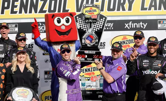 Denny Hamlin, left, holds up the trophy with a teammate after winning a NASCAR Cup Series auto race at Las Vegas Motor Speedway, Sunday, March 15, 2026, in Las Vegas. (AP Photo/Steve Marcus)
