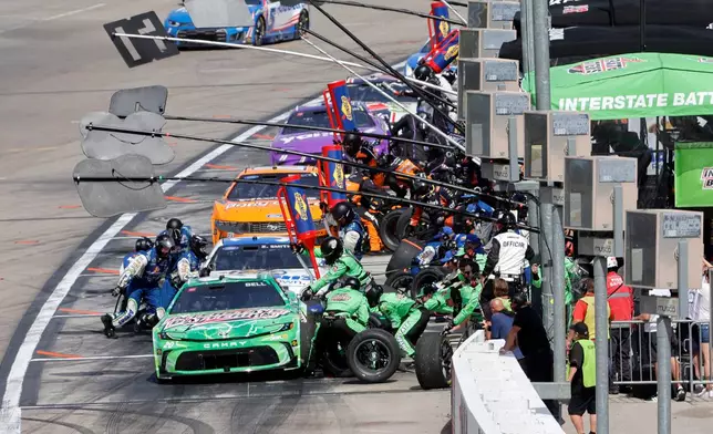 Driver Christopher Bell, foreground, and other drivers make pit stops during a NASCAR Cup Series auto race at Las Vegas Motor Speedway Sunday, March 15, 2026, in Las Vegas. (AP Photo/Steve Marcus)